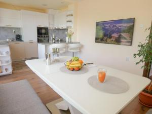 a white kitchen with a table with a bowl of fruit on it at Casa Central in Stara Zagora