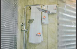 a shower with ailidas towels hanging on a wall at Ahaka cottages mbarara in Mbarara