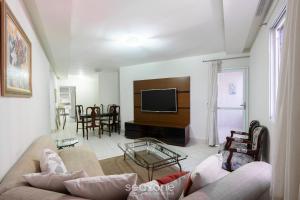 a living room with a couch and a tv at Apto no centro, a 300m da praia - VEL0102 in Guarapari