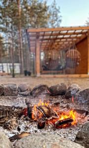 a fire pit with rocks and a gazebo at BORSKÓWKA all season domki z balią z jacuzzi I sauna in Borsk
