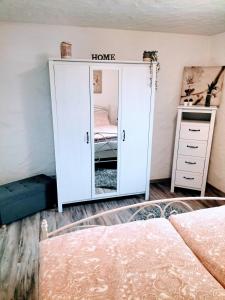 Schlafzimmer mit einem weißen Schrank und einem Spiegel in der Unterkunft Ferienwohnung Schneider in Münk