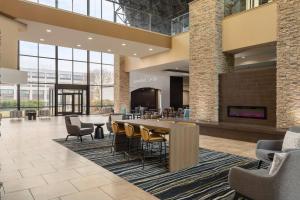 a lobby with a table and chairs and a fireplace at Holiday Inn Virginia Beach - Norfolk by IHG in Virginia Beach