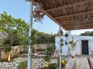 a patio with a wooden pergola at Sto al Trullo - Historic Trullo with Private Jacuzzi and Sauna in Martina Franca