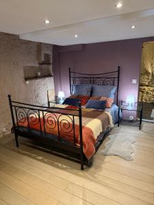a bedroom with a large bed with purple walls at Troglodyte du Petit Coteau in Vouvray