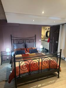 a bedroom with a bed with orange and blue pillows at Troglodyte du Petit Coteau in Vouvray