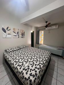 a bedroom with a bed with a black and white comforter at Casa ampla e aconchegante no coração de Ponta Negra in Natal