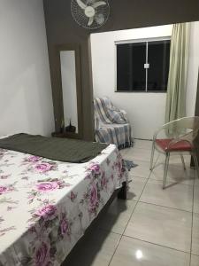 une chambre avec un lit, une chaise et une fenêtre dans l'établissement Casa Hamburgo 5 pessoas, à Búzios