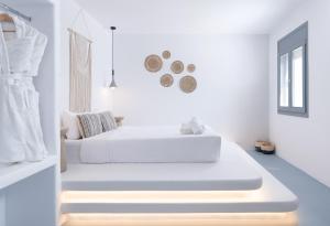 two beds in a room with white walls at Cilon Suites Santorini in Imerovigli