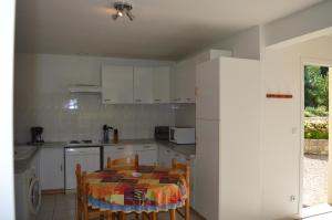 a kitchen with a table and a table and chairs at le moulin in Vallon-Pont-dʼArc