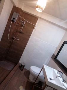 un baño con inodoro y lavabo en Comfortable Lodge, en San Antonio 1 foto más