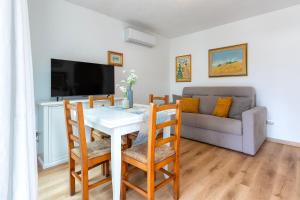 un soggiorno con un tavolo e un divano di Casa Sergio a Olbia