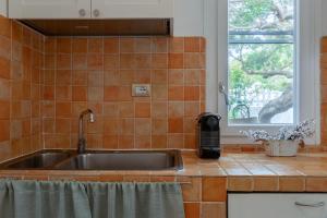 una cucina con lavandino in acciaio inossidabile e finestra di Casa Sergio a Olbia Altre 45 foto