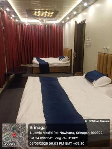 シュリーナガルにあるWinter Wonder Home Stayの赤いカーテンの部屋にベッドが2つある