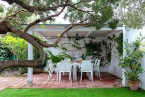 un tavolo e sedie su un patio sotto un albero di Casa Sergio a Olbia