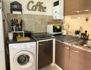 una cocina con lavadora y microondas en Plain pied - Appartement dans résidence sous les pins, en Cap d'Agde