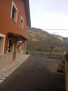 a building with a parking lot next to a hill at Apartamentos Picos de EUROPA in Dego +5 photos