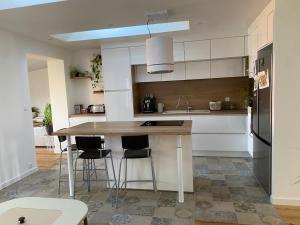 a kitchen with a table and stools in it at Maison familiale Tarnos, 4 chambres, jacuzzi in Tarnos +17 photos