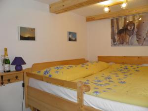 1 dormitorio con 1 cama con sábanas amarillas y flores azules en Bungalov Mladé Buky, en Mladé Buky