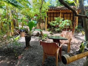 a garden with a table and chairs and a house at Cabaña el ojoche in Balgue