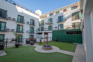 a courtyard with a fountain in the middle of a building at The Residences Apart-Hotel By Morgan in Cabo San Lucas +17 photos