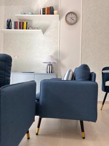 sala de estar con 2 sillas azules y reloj en Suite Azzurra, en Tropea
