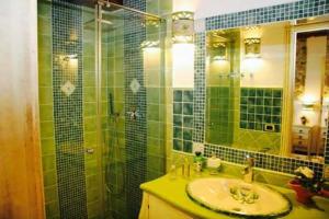 a green tiled bathroom with a sink and a shower at Romeo e Giulietta Scilla in Scilla