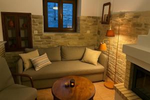 a living room with a couch and a fireplace at Panorama Traditional Village House in Kamarítsa