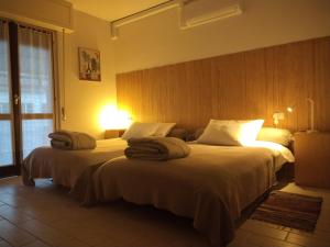 a hotel room with two beds with towels on them at Valtellina -La Casina Sondrio in Sondrio