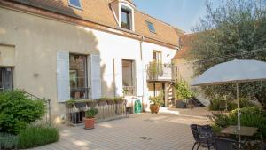 a patio with a table and an umbrella at Chambre d'hôtes option étape pour professionnel in Morangis