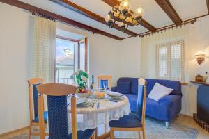 Una sala de estar con una mesa y un sofá azul. en Casa Patrizia - Happy Rentals, en Caviano