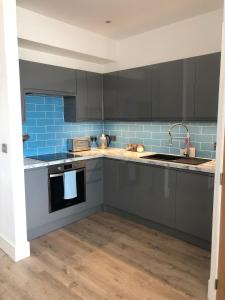 セント・アイヴスにあるDixies View - 2 bed apartment - Central St Ivesの青いタイルのキッチン(グレーのキャビネット付)