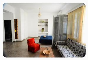 a living room with a couch and a red chair at The SPiTi Project 23 in Kavála