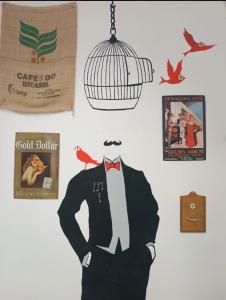a man in a suit and a bird cage on a wall at The SPiTi Project 23 in Kavála
