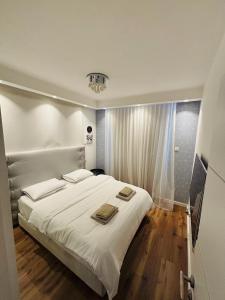 Un dormitorio con una cama blanca con dos toallas encima. en Golf Residence Suite & pool, en Eilat 29 fotos más