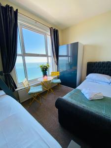 a bedroom with a bed and a large window at Villa Mentone Hotel in Shanklin