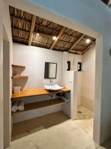 a bathroom with a sink and a computer monitor on the wall at Casa Terra in Paso Hondo +7 photos