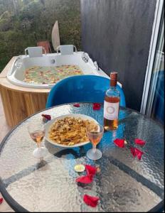 a table with a plate of food and a bottle of wine at Cabaña Celestial in Guarne