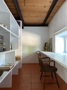 a dining room with a desk and a chair at Casa das Ribeiras in Azoia de Baixo