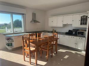 a kitchen with a wooden table and chairs at CASA Nieves in O Grove