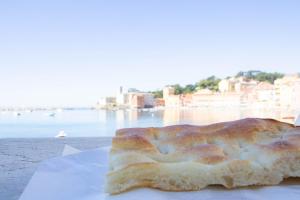 a piece of bread sitting on a plate next to the water at 245c - Casa Johanna, Centro Storico, 140metri dalla Baia del Silenzio PATRIMONIO UNESCO spiaggia e mare in Sestri Levante +15 photos