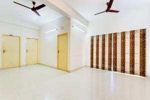 two ceiling fans in an empty room with two doors at Hotel O J2 Service Apartment in Chennai +36 photos