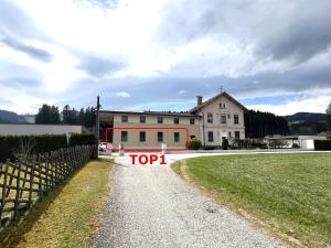 ein großes weißes Haus mit einem Schild mit der Aufschrift „Top“ in der Unterkunft Lavanttalbahn Suite in Mauterndorf