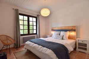 ein Schlafzimmer mit einem Bett und einem großen Fenster in der Unterkunft Maison à 300 m de la plage et centre avec piscine in La Couarde-sur-Mer