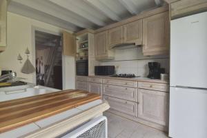eine Küche mit Holzschränken und einer Arbeitsplatte in der Unterkunft Maison à 300 m de la plage et centre avec piscine in La Couarde-sur-Mer