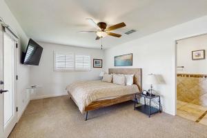 Un dormitorio con una cama y un ventilador de techo. en Born Country, en Kingsland