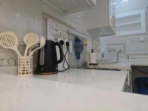 a kitchen counter with a tea kettle and spoons at Al Diyafah Apt in Medina