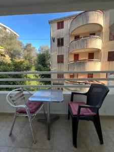 a table and chairs on a balcony with a building at Quiet Studio Bečići Garage available 5 e per day in Boreti