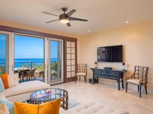 a living room with a couch and a piano at Totally Revamped Pacific Paradise J505 At Wbv! -Top Floor Ocean Views! in Wailea