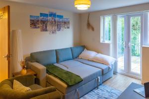 un soggiorno con un divano blu davanti a una finestra di The Vogue Stay, 3 Bedrooms, 2 bathrooms, Ideal for JR & Oxford Hospitals, FREE CarPark, Conveniently located for Ring Road access, 2 miles from Oxford City Centre easy car & bus route a Oxford