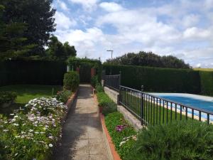 a garden with flowers and a fence next to a pool at Casa La Laguneta in Arcos de la Frontera +7 photos